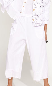 Front bottom half view of a woman wearing the banana blue solid white pant. This pant has two front pockets and a wide cropped cut.
