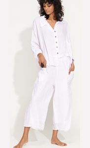 front full body view of a woman wearing the banana blue solid white pant with a white shirt. This pant has two front pockets and a wide cropped cut.