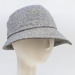 Load image into Gallery viewer, Front right side view of the lillie &amp; cohoe herringbone vintage phoebe hat. This hat has an asymmetrical pointed brim, a layered crown, and a grey herringbone pattern.
