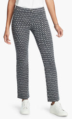 Load image into Gallery viewer, Front, bottom half view of a woman wearing the Nic + Zoe Ponte Ikat Pant. These pants are indigo with white speckled print. They have a straight leg and sit above the ankles.
