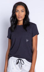Load image into Gallery viewer, Front top half view of a woman wearing the PJ Salvage Lily Rose Tee. The short sleeve t-shirt is black and has a single front pocket on the left side with a tiny french bulldog face printed on it.
