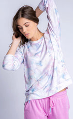 Load image into Gallery viewer, Front top half view of a woman with her hands behind her head and wearing the PJ Salvage Marble top. This top has a soft pink and blue marble print and long sleeves. On the bottom the woman is wearing a pink lounge pant.
