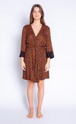 Load image into Gallery viewer, Front full body view of woman wearing the PJ Salvage Wild Love Robe. This short, mocha/brown colored robe has a heart shaped animal print all over it, contrasting black sleeves, and a belt at the waist.
