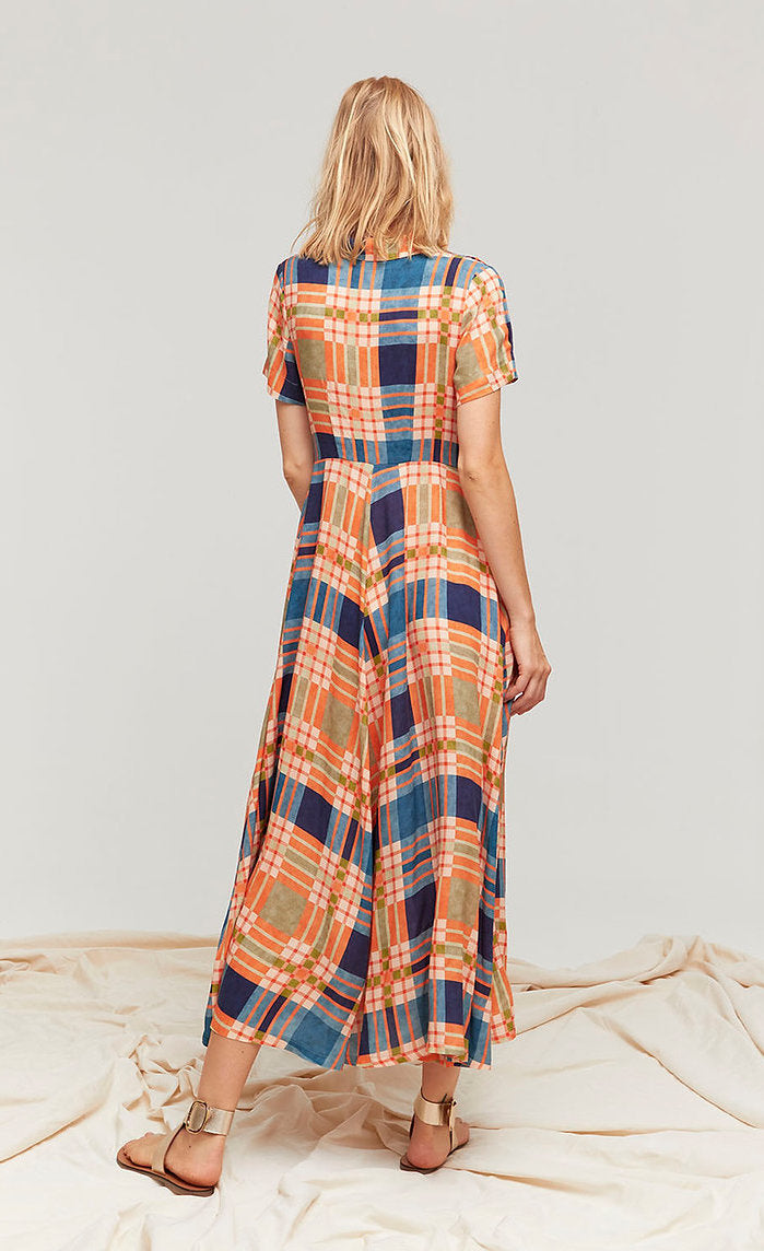 Back full body view of a woman wearing the orange green, and blue plaid aldo martins arlet dress.