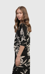 Load image into Gallery viewer, left side top half view of a woman wearing the alembika ciao ciao floral blouson.
