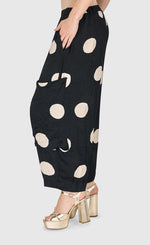 Load image into Gallery viewer, Left side bottom half view of a woman wearing the Alembika Circles Party Pants
