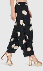 Load image into Gallery viewer, Right side bottom half view of a woman wearing the Alembika Circles Party Pants
