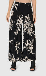 Load image into Gallery viewer, Front bottom half view of a woman wearing the floral bendetta palazzo pants
