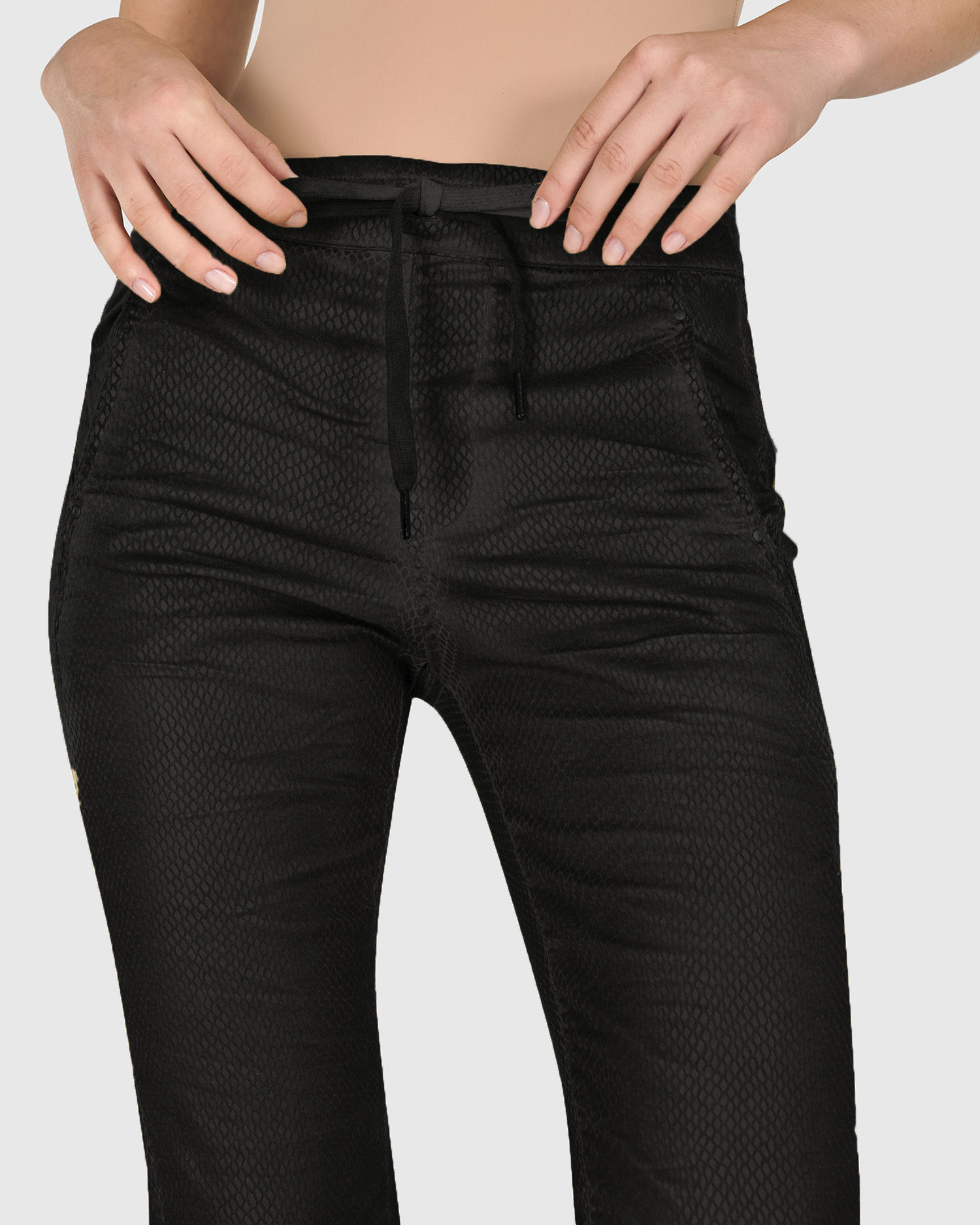 Front close up view of a woman wearing the alembika iconic stretch jean in black snake