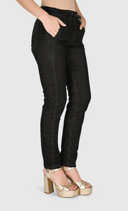 Right side bottom half view of a woman wearing the alembika iconic stretch jean in black snake