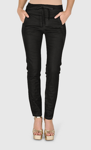 Front bottom half view of a woman wearing the alembika iconic stretch jean in black snake