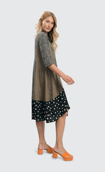 Load image into Gallery viewer, Right side full body view of a woman wearing the alembika meredith trapeze shirtdress. 
