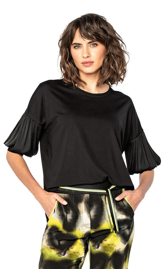 Front top half view of a woman wearing the black half sleeve blouse.