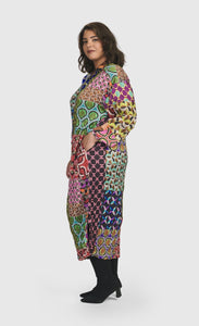Left side full body view of a woman wearing the Alembika Lucy Kaleidoscope Maxi Dress