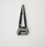 Load image into Gallery viewer, Gray crossbody bag with a black strap on a light gray background
