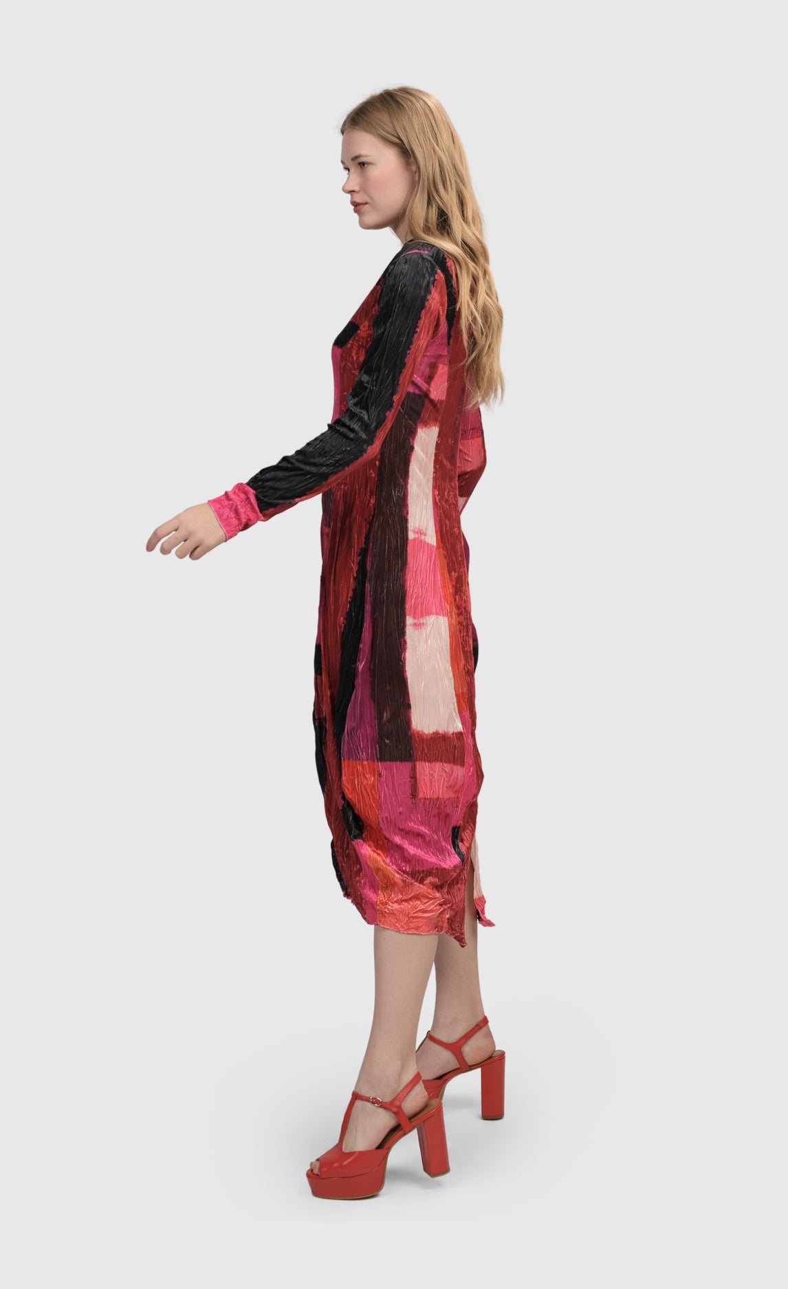 Left side full body view of a woman wearing the Alembika Sunset Strip Cocoon Magenta Dress