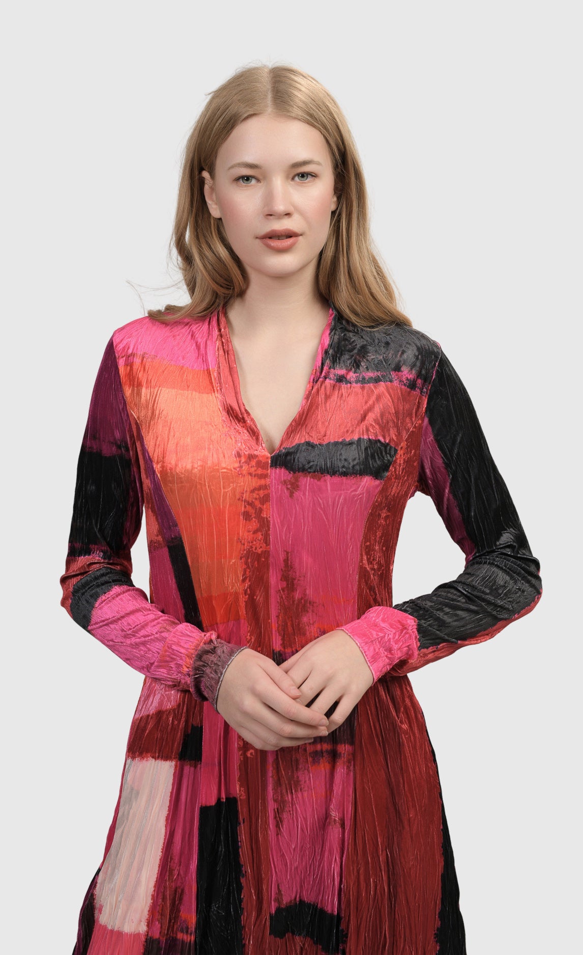 Front top half view of a woman wearing the Alembika Sunset Strip Cocoon Magenta Dress