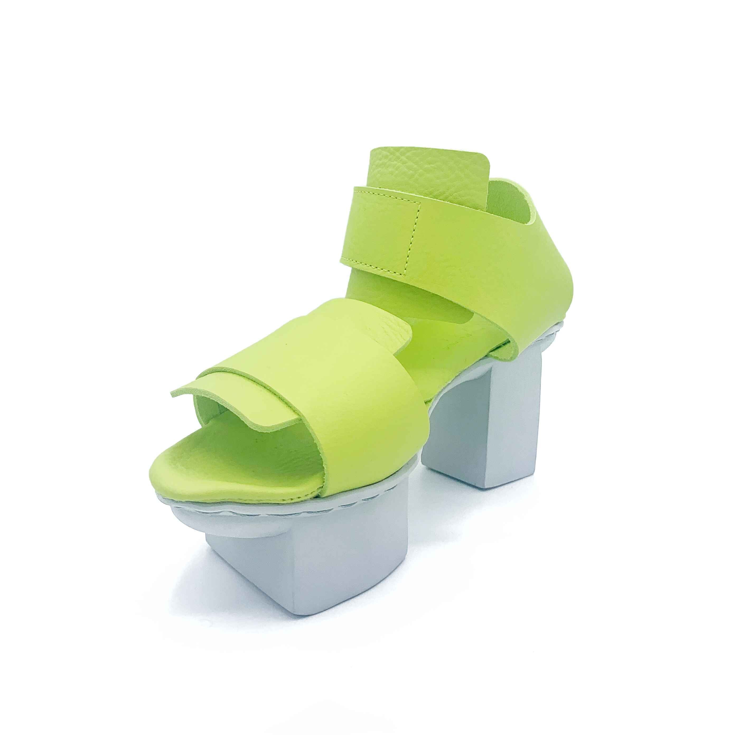 Inner front side view of the trippen visor shoe in the color lime with a white sole.