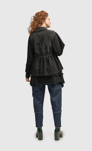 Back full body view of a woman wearing the Alembika Urban Strut Poker Jacket
