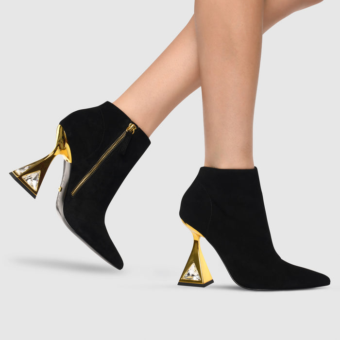 Outer and inner side view of a woman wearing the kat maconie sofi boots in black/gold.