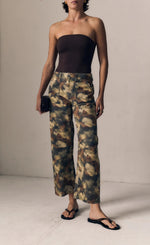 Load image into Gallery viewer, A model wearing a dark brown strapless tube top and wide-leg cropped pants with a brown, beige, and black tie-dye pattern, paired with black flip-flops against a neutral studio backdrop.

