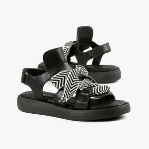 front view of a pair of the all black footwear bowlace sandal