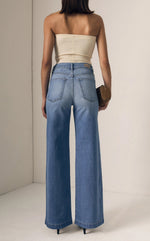 Load image into Gallery viewer, Person wearing a beige strapless top and blue jeans against a plain background
