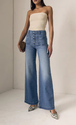 Load image into Gallery viewer, Woman wearing a strapless top and high-waisted jeans on a plain background
