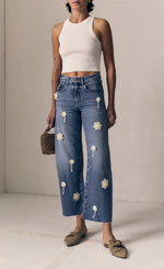 Load image into Gallery viewer, Person wearing distressed blue jeans and a white top on a plain background
