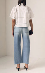 Load image into Gallery viewer, Person wearing a white top and light blue jeans against a plain background
