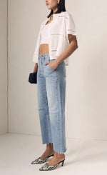 Load image into Gallery viewer, Woman wearing a white jacket and blue jeans against a plain background
