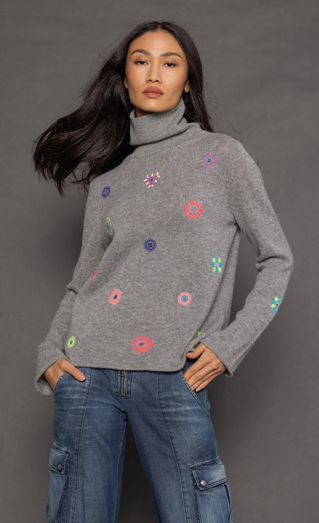 Front top half view of a woman wearing the lisa todd lucky charm sweater in heather grey.