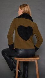 Load image into Gallery viewer, Back Full body view of a woman wearing the Lisa Todd No Limits Jacket in the color olive with black sherling trim.
