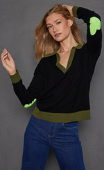 Load image into Gallery viewer, Front top half view of a woman wearing the lisa todd polo pop in onyx with green trim light green hearts on the elbows.
