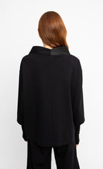 Load image into Gallery viewer, Back top half view of a woman wearing the ozai n ku black cardigan.
