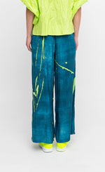Load image into Gallery viewer, Back full body view of a woman wearing the ozai n ku ocean breeze pants.
