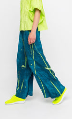 Load image into Gallery viewer, Left side lower body view of a woman wearing the ozai n ku ocean breeze pants.

