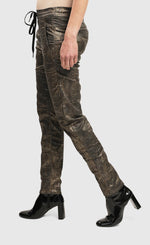 Load image into Gallery viewer, Left side bottom half view of a woman wearing the Alembika Bronze Iconic Jeans Desires 
