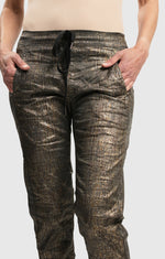 Load image into Gallery viewer, Front close up bottom half view of a woman wearing the Alembika Bronze Iconic Jeans Desires 
