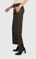 Load image into Gallery viewer, Left side bottom half view of a woman wearing the alembika Dynamite Days Straight Leg Pants in coffee.
