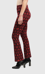 Load image into Gallery viewer, Left side bottom half view of a woman wearing the Alembika Dynamite Days Bell Bottom Red Pants
