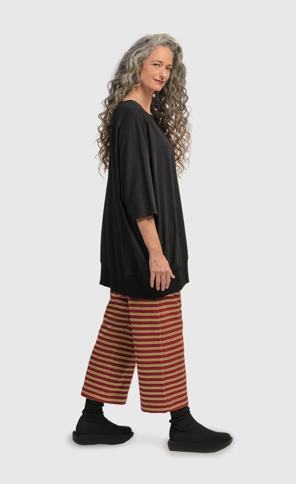 Right side view of a woman wearing the Alembika Urban Red Striped Pant