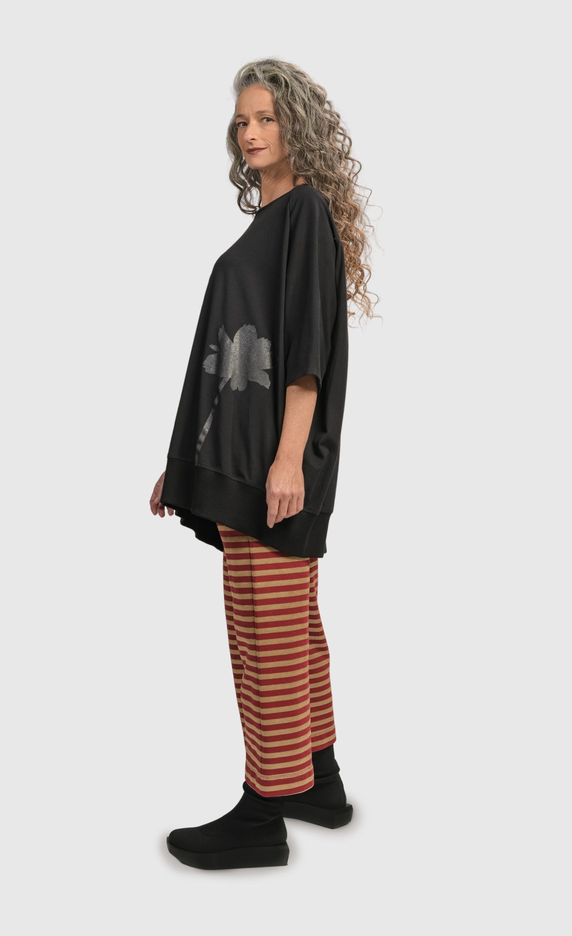 Left side view of a woman wearing the Alembika Urban Red Striped Pant