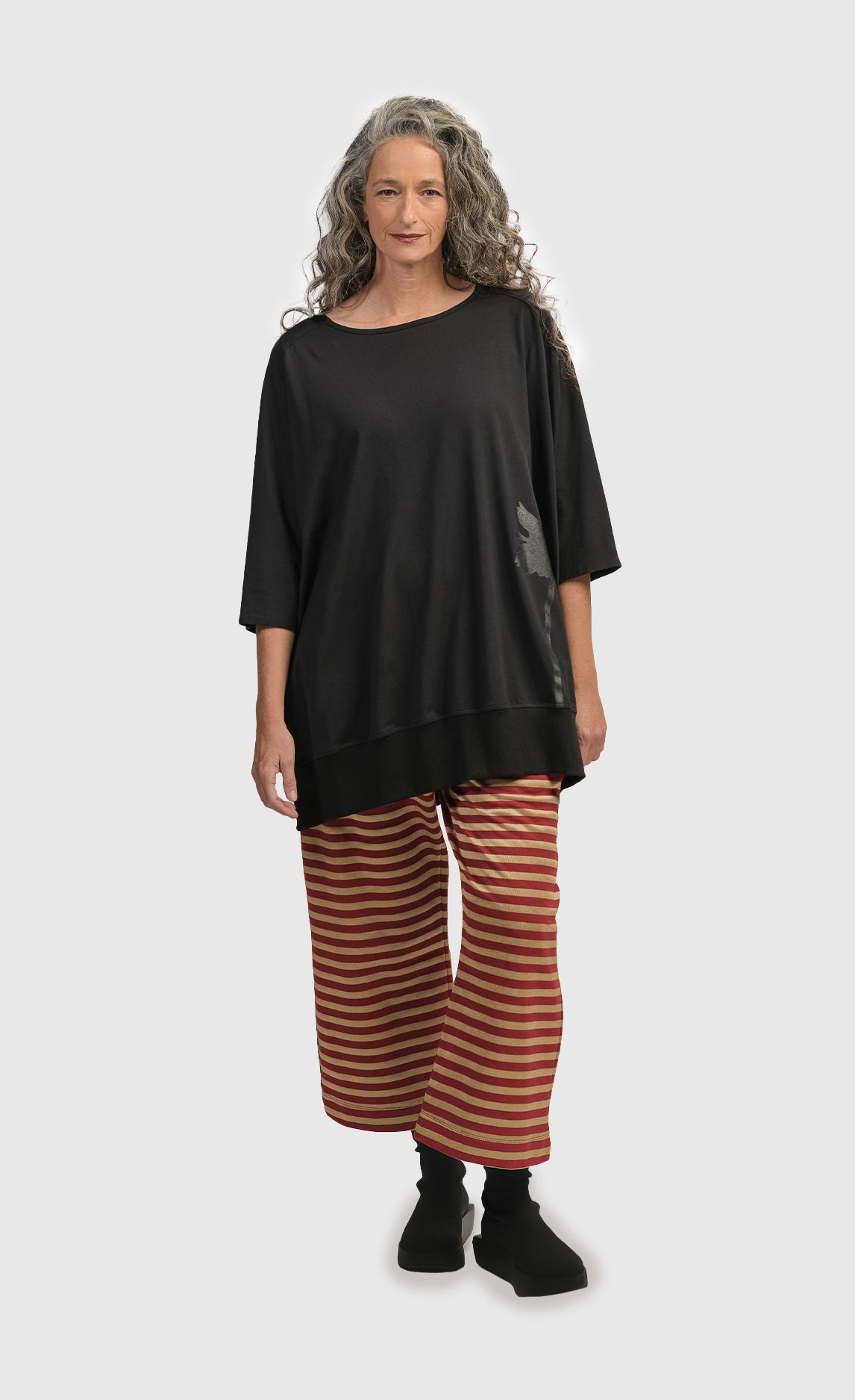 Front full body view of a woman wearing the Alembika Urban Red Striped Pant