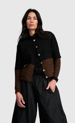 Load image into Gallery viewer, A woman modeling a black and brown color-blocked button-up cardigan with wide-leg black pants, photographed against a solid light gray background.
