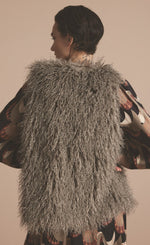 Load image into Gallery viewer, Back top half view of a woman wearing the summum faux fur gilet in clay.

