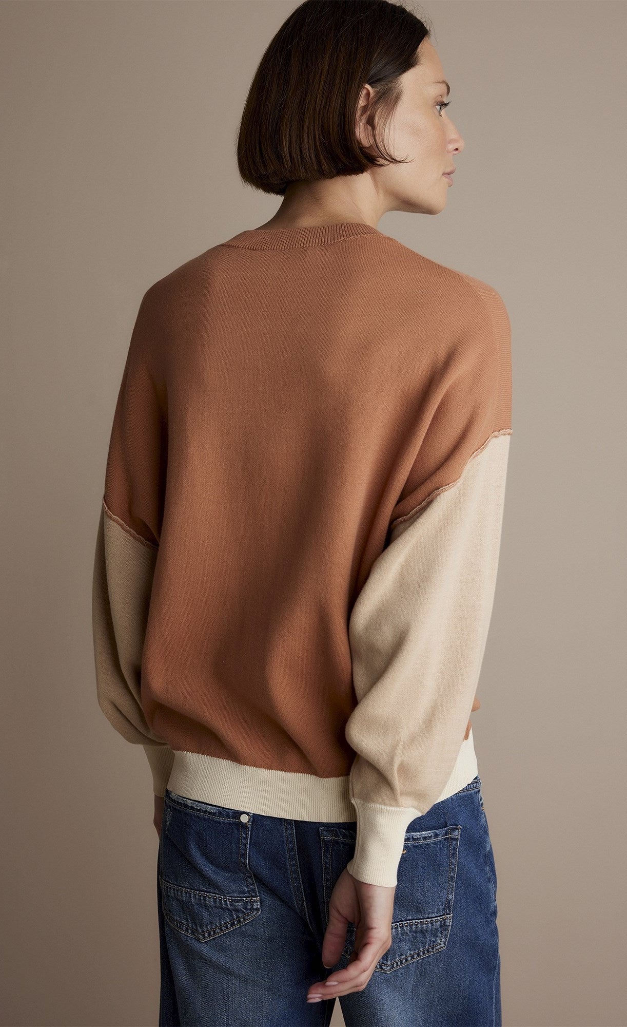 Back top half view of a woman wearing the summum double bed jumper with puff sleeves.