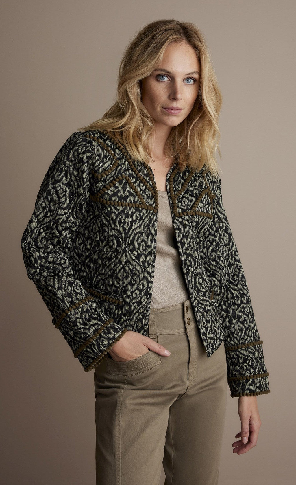 Front top half view of a woman wearing the summum lightly quilted jacket.