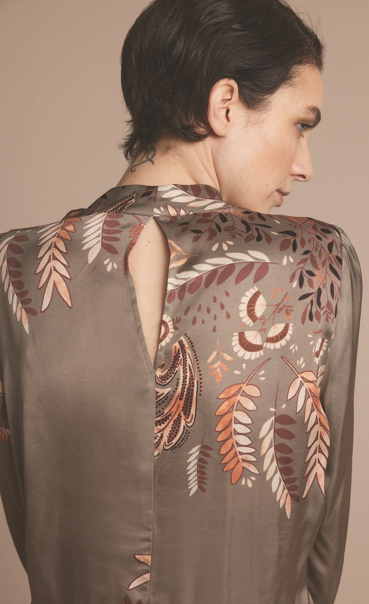 Back close up view of a woman wearing the summum leaves top with long puff sleeves.