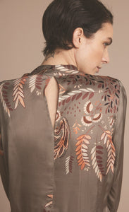Back close up view of a woman wearing the summum leaves top with long puff sleeves.